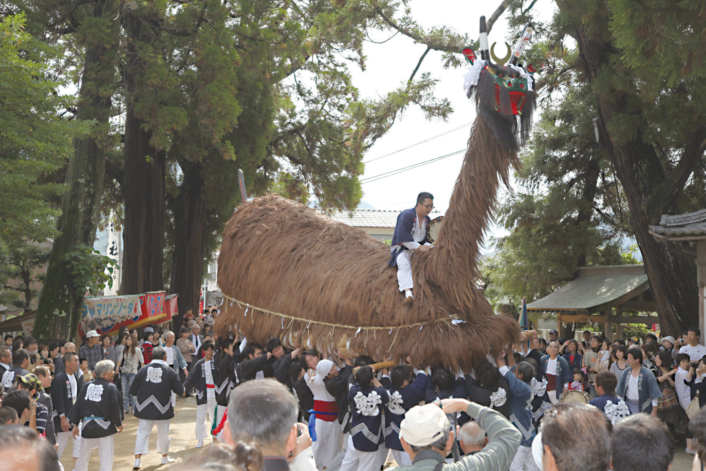 牛鬼に乗り、太鼓を打ち鳴らす男性